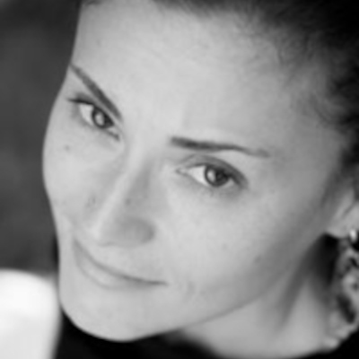 Andrea Scarpino looking upward with a subtle smile in a black and white close-up.